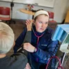 A student takes a community member's blood pressure.
