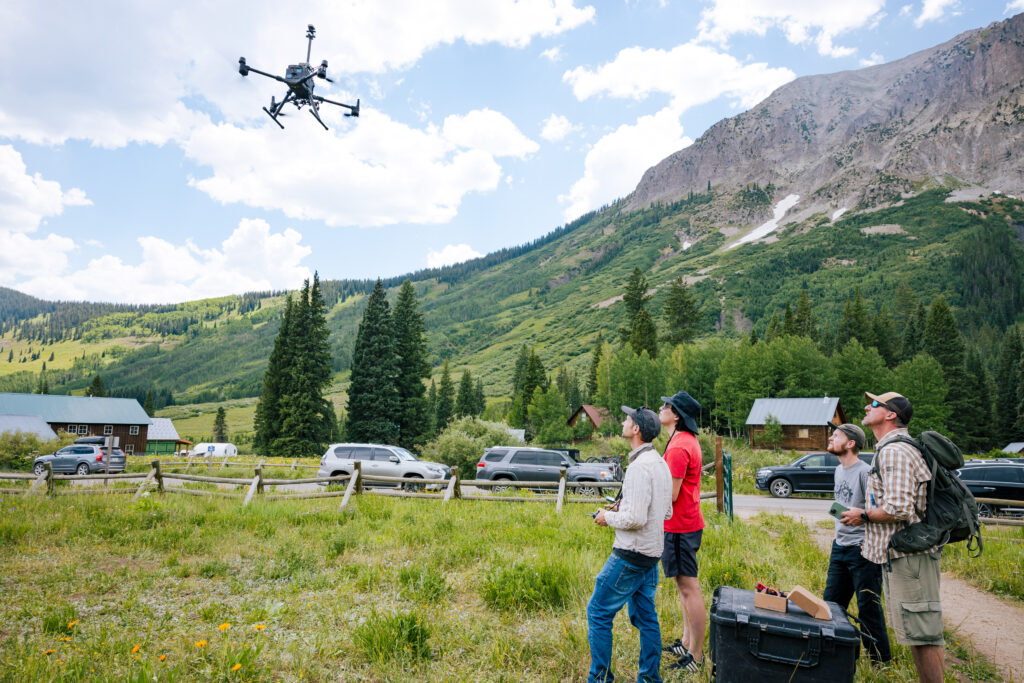 A group watches a drone take off in Gothic, Colorado.