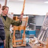A professor gives feedback to her student next to her on her painting