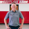 Van Hee poses in front of the Wrestling locker room.