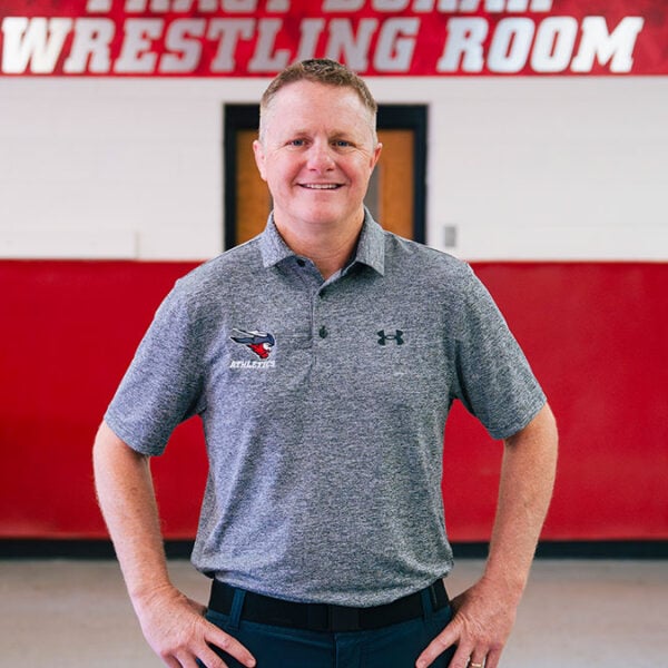 Van Hee poses in front of the Wrestling locker room.