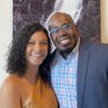 Jermaine poses with his partner in front of a painting.