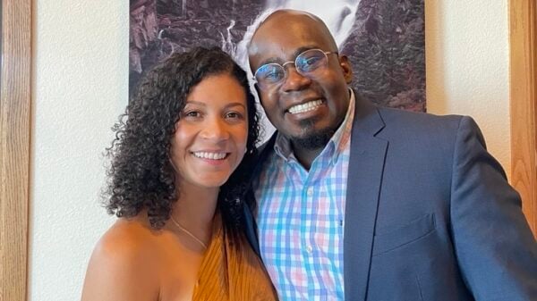 Jermaine poses with his partner in front of a painting.