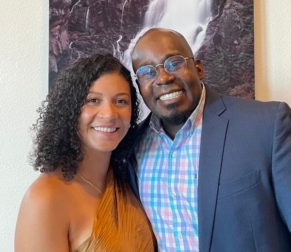 Jermaine poses with his partner in front of a painting.