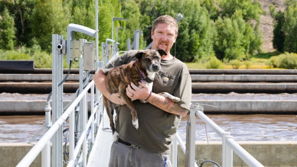 Don Getz, Wastewater Superintendent, holds his dog for a photo at the treatment plant.