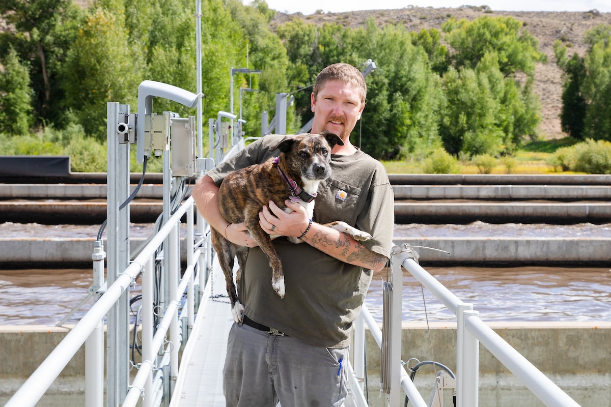 Don Getz, Wastewater Superintendent, holds his dog for a photo at the treatment plant.